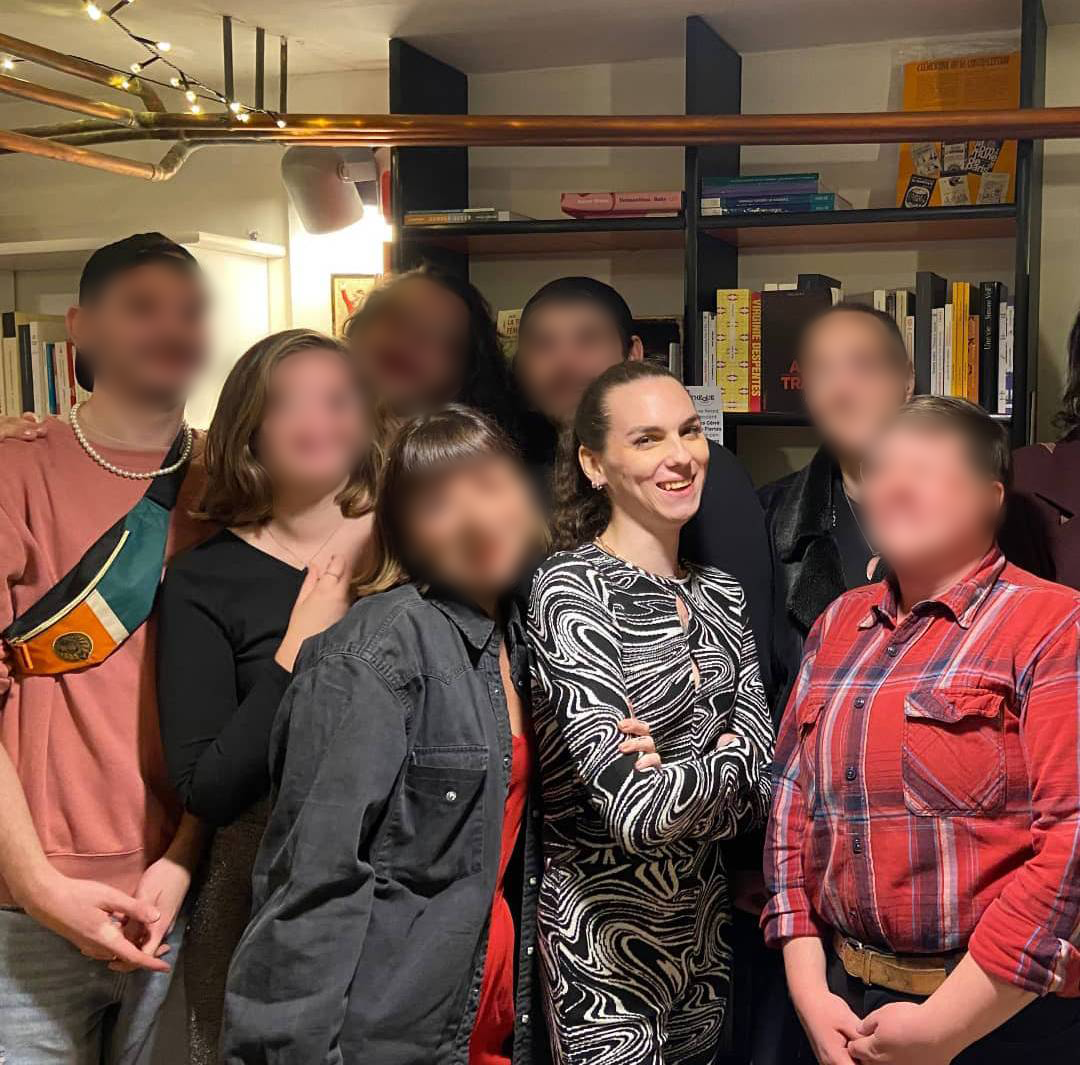 Une photo de Lexi Aggresti, entourée de bénévoles de Fiertés Colorées, visages floutés;